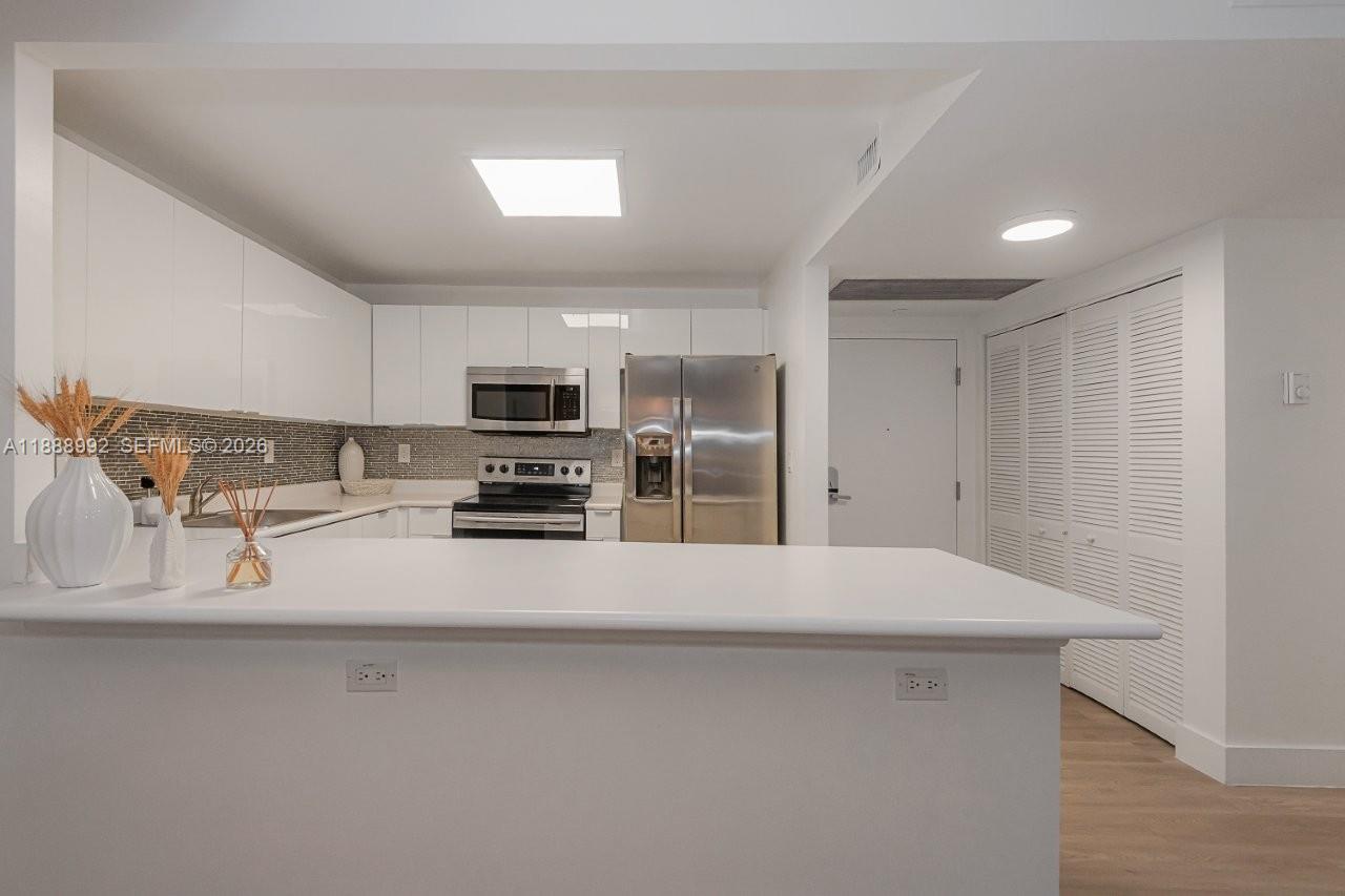 2301 Collins Avenue, Unit 333 Miami Beach, FL 33139 - Photo 13 of 37 a kitchen with stainless steel appliances a refrigerator and a stove top oven