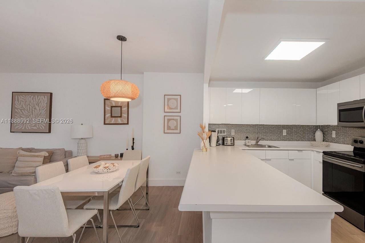 2301 Collins Avenue, Unit 333 Miami Beach, FL 33139 - Photo 15 of 37 a kitchen with a table chairs and white appliances