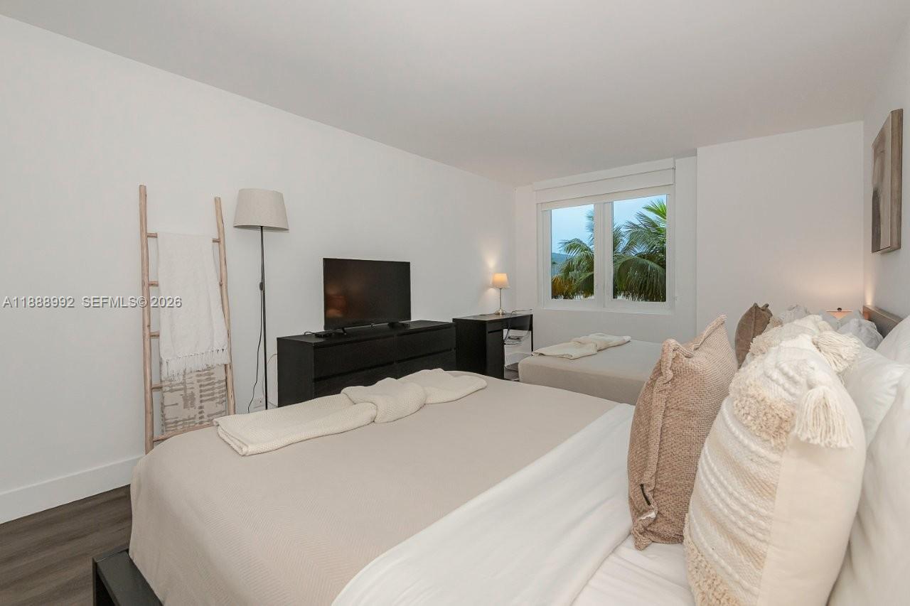 2301 Collins Avenue, Unit 333 Miami Beach, FL 33139 - Photo 21 of 37 a large bedroom with bed and a flat tv screen on the dresser