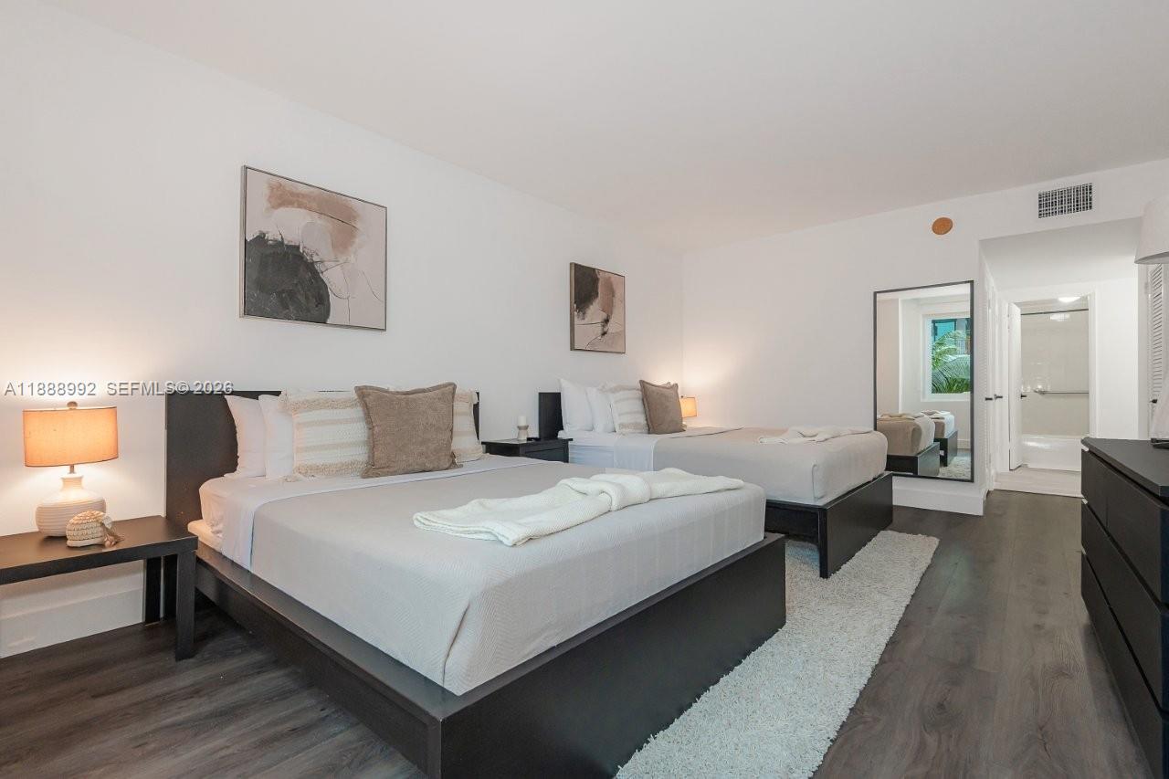 2301 Collins Avenue, Unit 333 Miami Beach, FL 33139 - Photo 23 of 37 a large bedroom with bed and a night stand