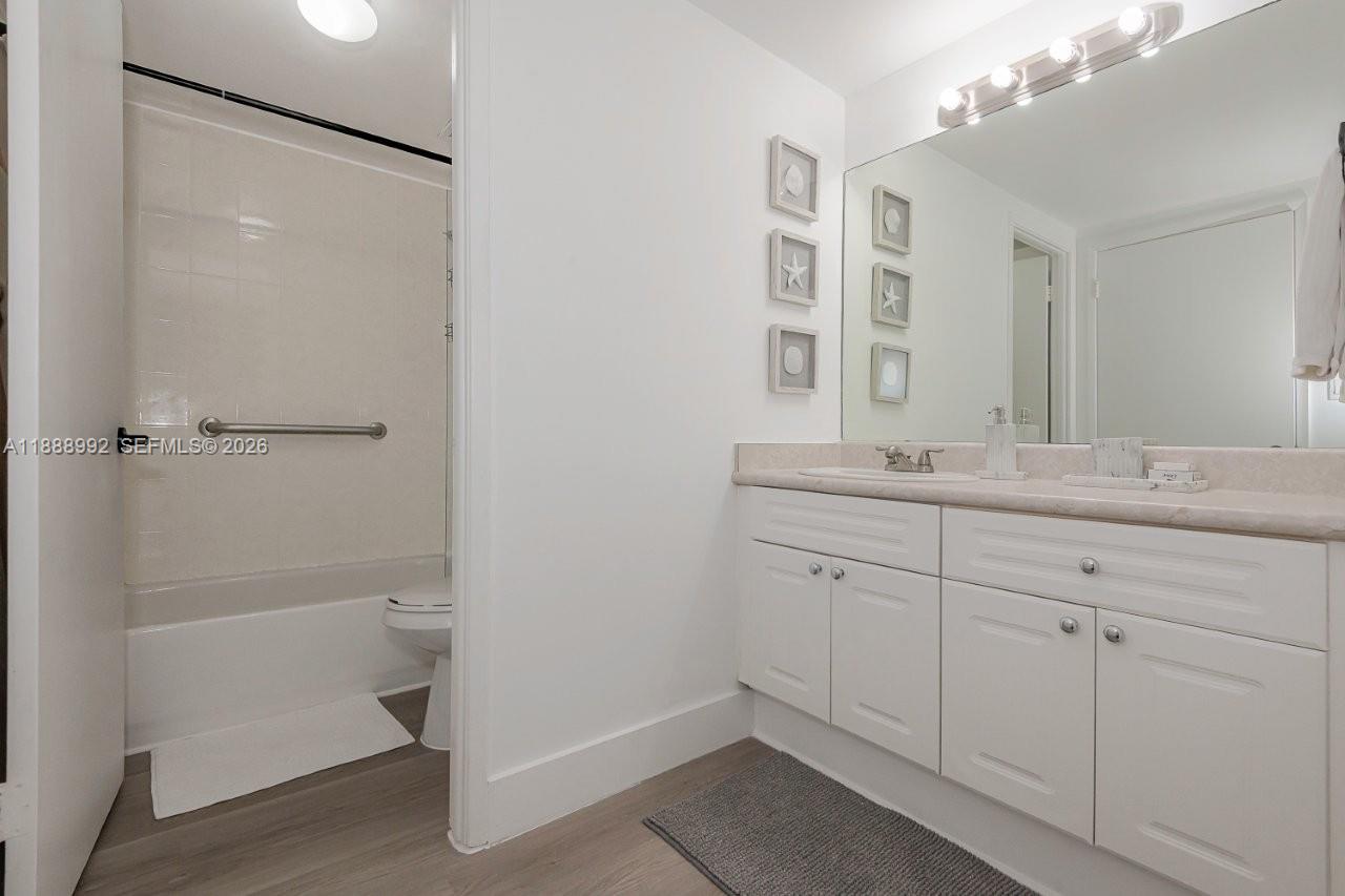 2301 Collins Avenue, Unit 333 Miami Beach, FL 33139 - Photo 24 of 37 a bathroom with a shower sink vanity and mirror