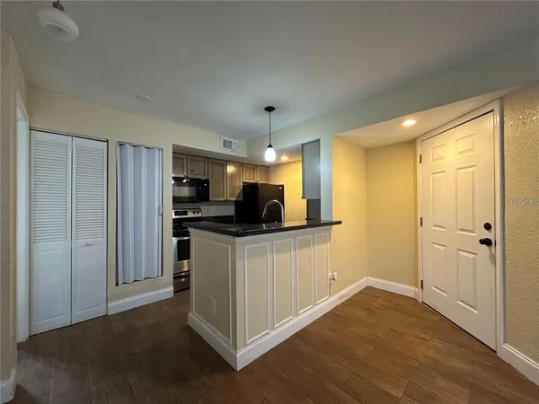 a kitchen with stainless steel appliances granite countertop a refrigerator and a stove top oven
