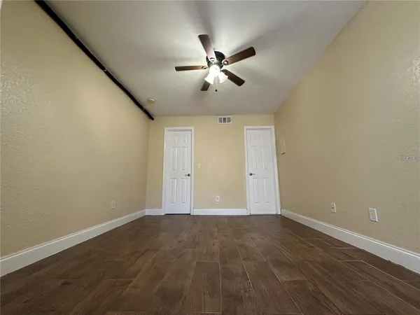 a view of an empty room with wooden floor