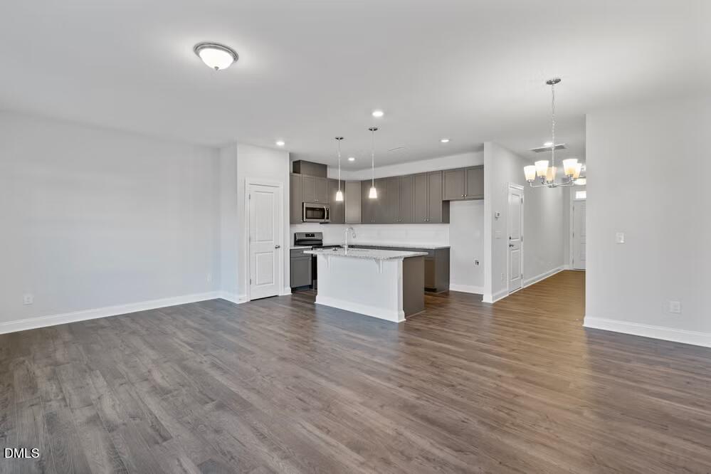 520 Eversden Drive Zebulon, NC 27597 - Photo 8 of 24 a view of an empty room and kitchen with wooden floor
