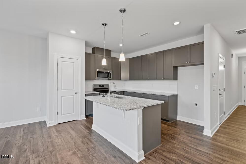 520 Eversden Drive Zebulon, NC 27597 - Photo 9 of 24 a kitchen with stainless steel appliances granite countertop a sink stove and refrigerator