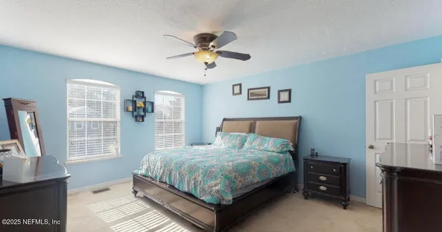 a bedroom with a bed and a flat tv screen on dresser