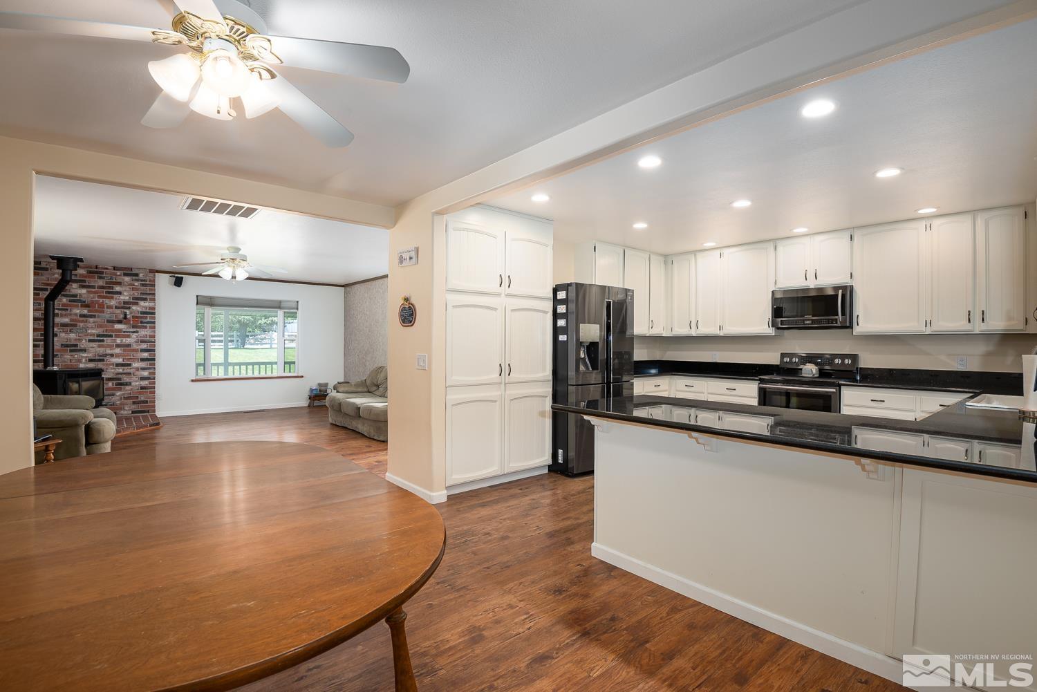 270 Kitts Way Reno, NV 89521 - Photo 6 of 16 a kitchen with stainless steel appliances a dining table chairs refrigerator and sink