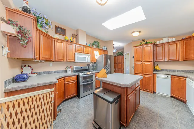 a kitchen with stainless steel appliances granite countertop a sink a stove and refrigerator