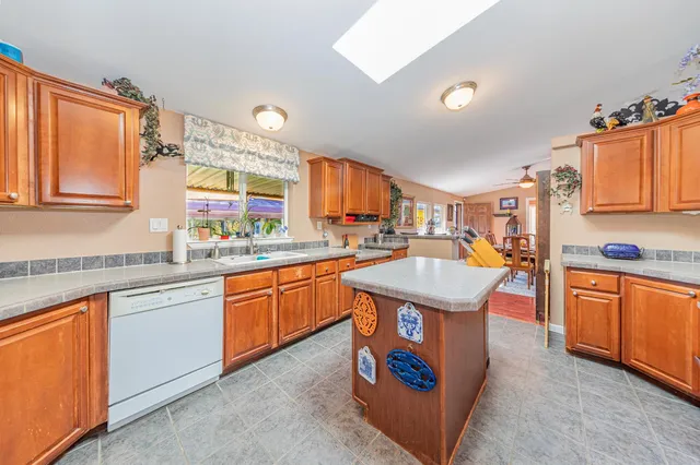 a kitchen with stainless steel appliances granite countertop a refrigerator a stove and a sink