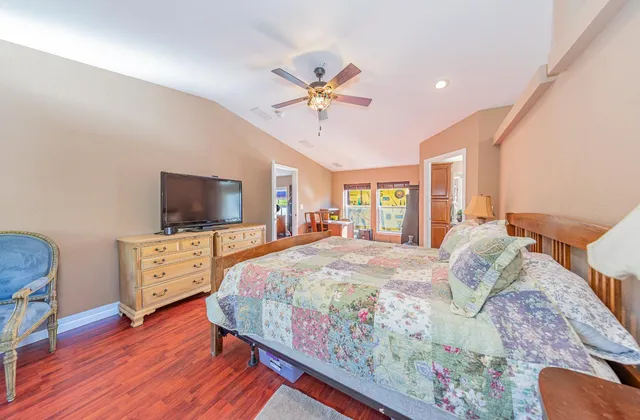 a large bedroom with a bed and wooden floor