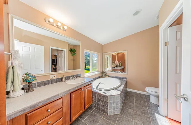 a spacious bathroom with a granite countertop tub sink and mirror