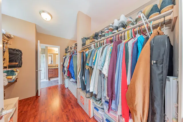 a view of walk in closet with clothes and shoes