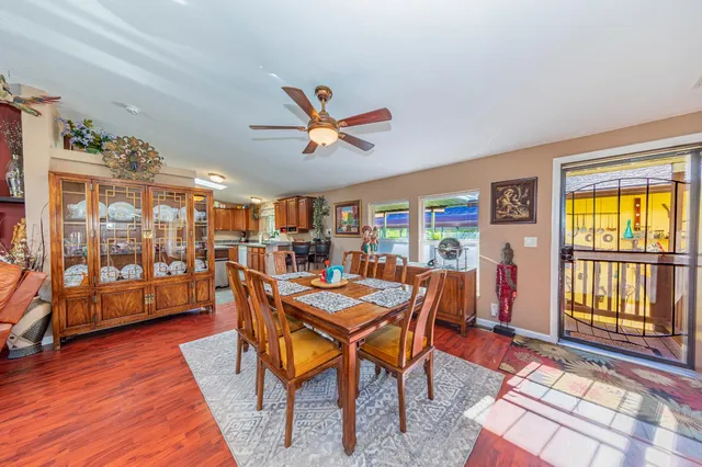 a kitchen with stainless steel appliances kitchen island granite countertop a table chairs a sink and a refrigerator