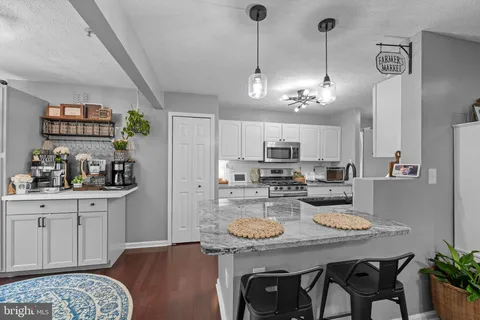 a view of a dining room and livingroom with furniture wooden floor a chandelier