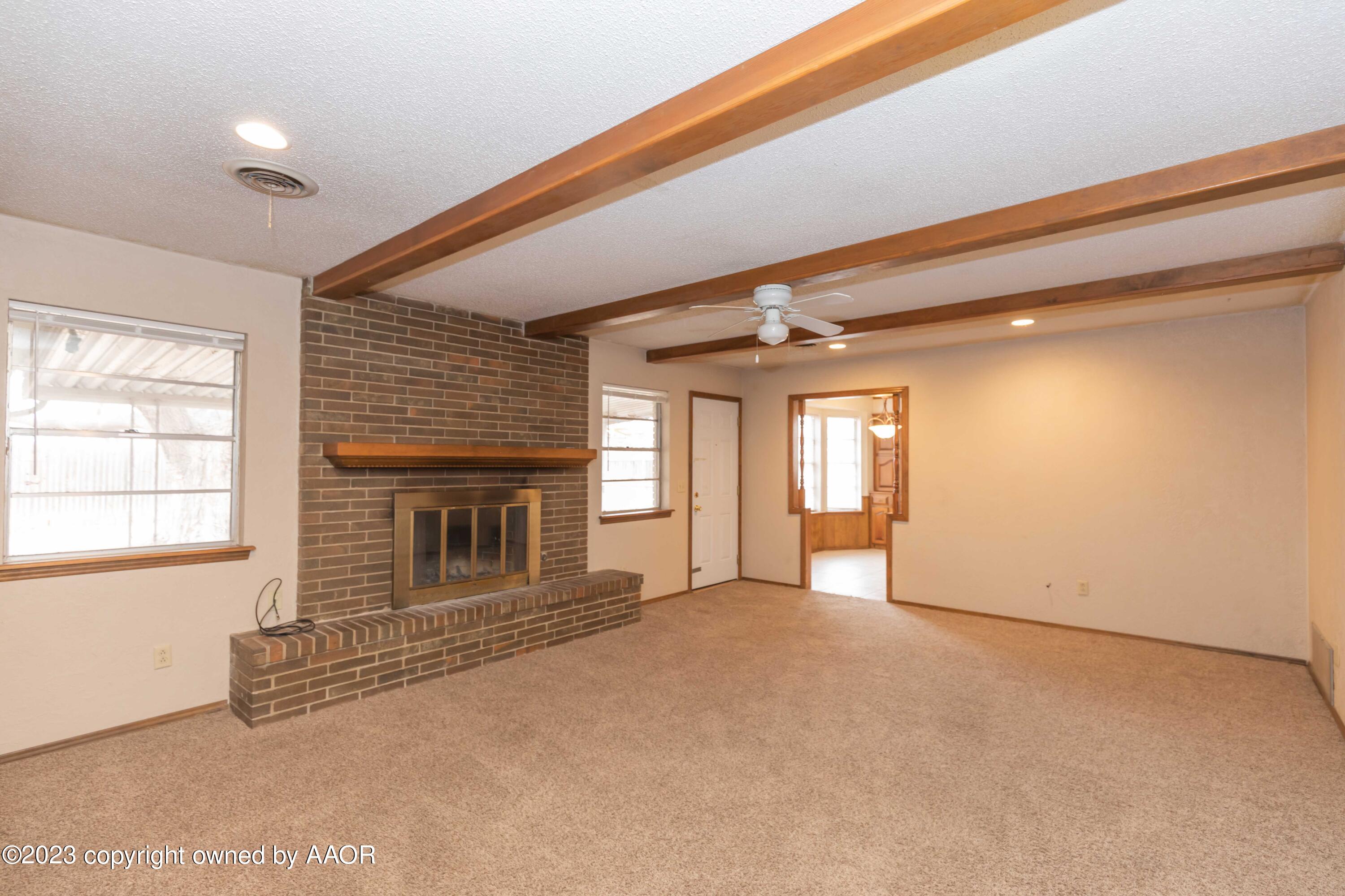 3410 Harmony Street Amarillo, TX 79109 - Photo 15 of 41 a view of an empty room with a fireplace and a window
