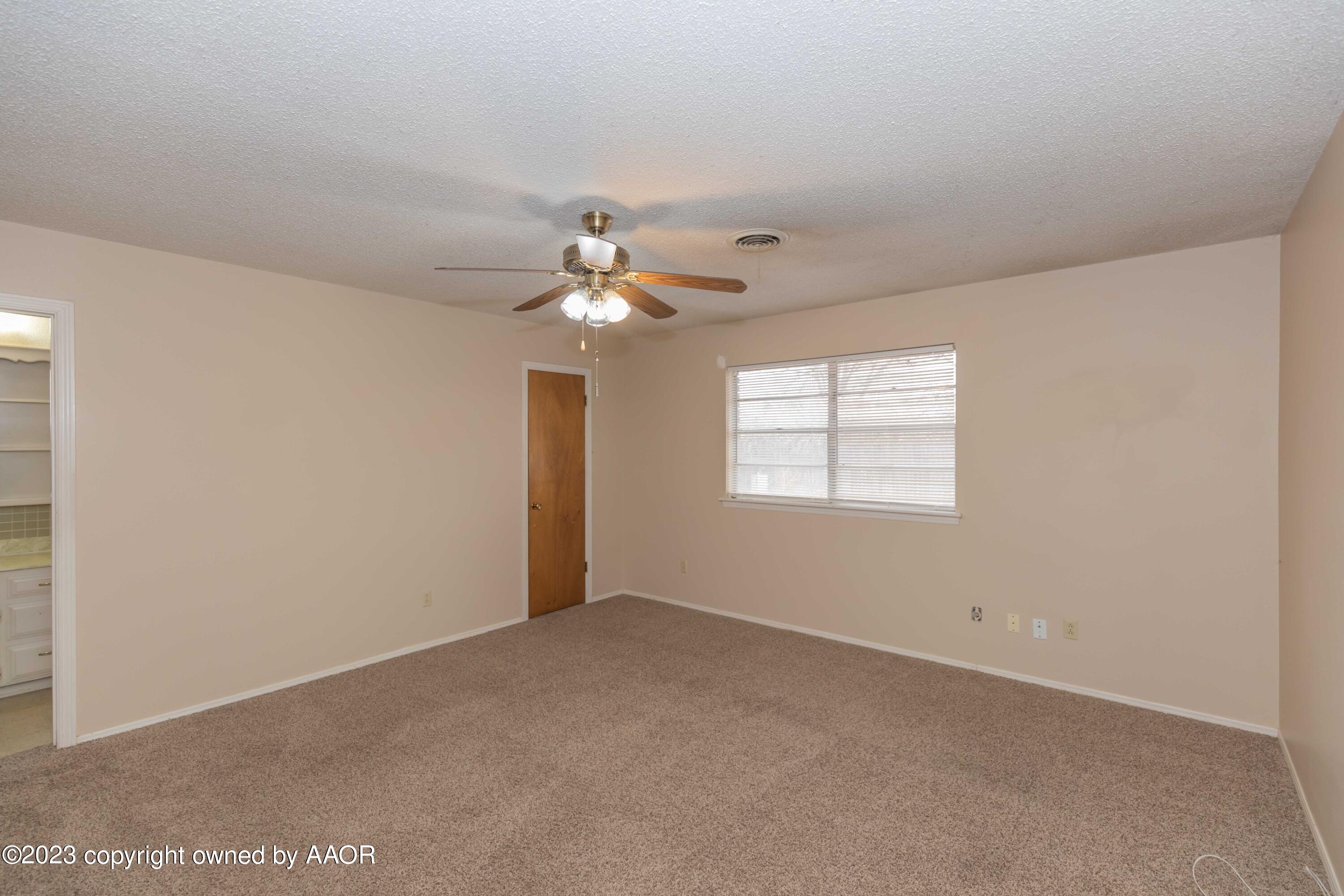3410 Harmony Street Amarillo, TX 79109 - Photo 19 of 41 en empty room with windows and chandelier fan