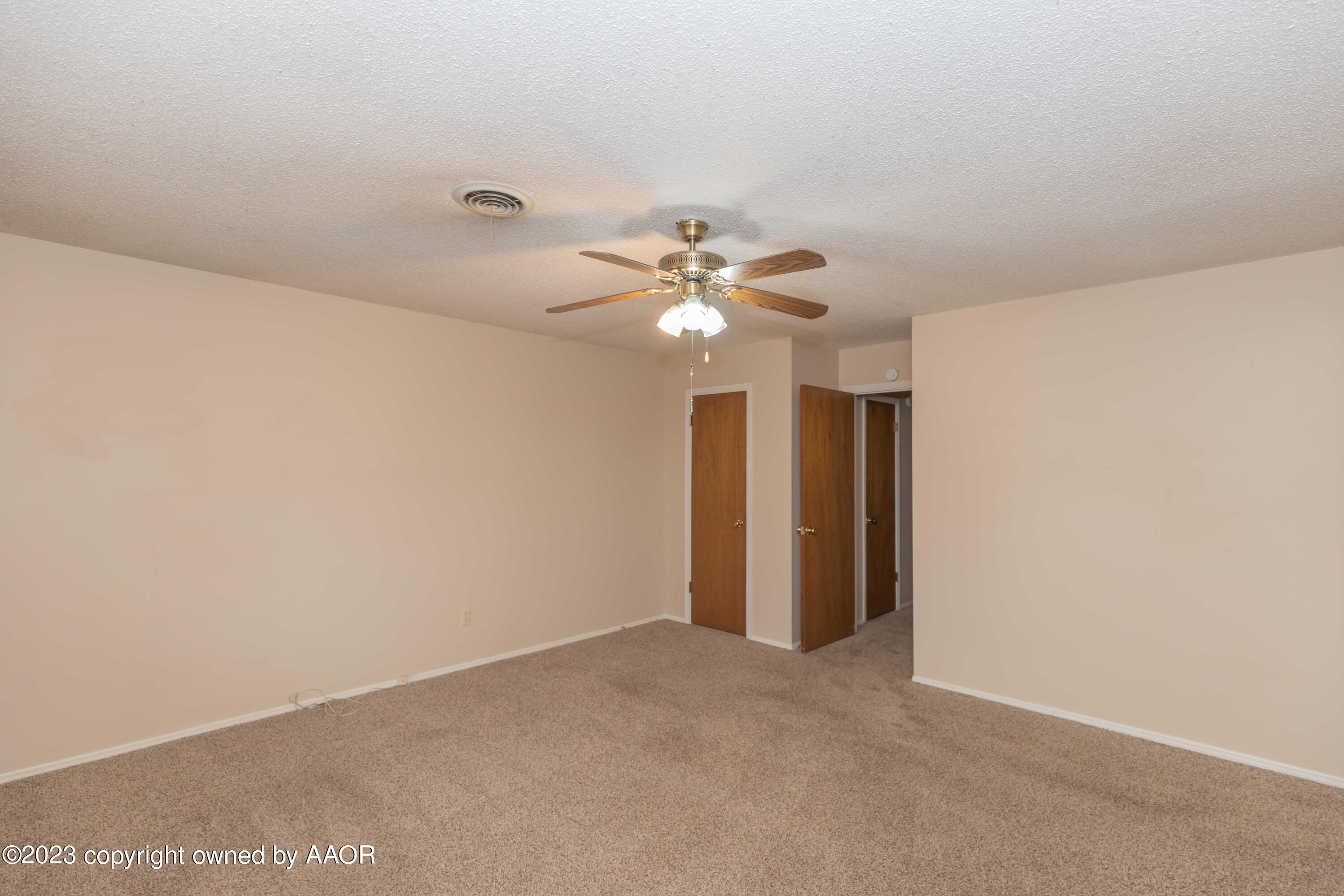 3410 Harmony Street Amarillo, TX 79109 - Photo 21 of 41 an empty room with a chandelier fan and windows