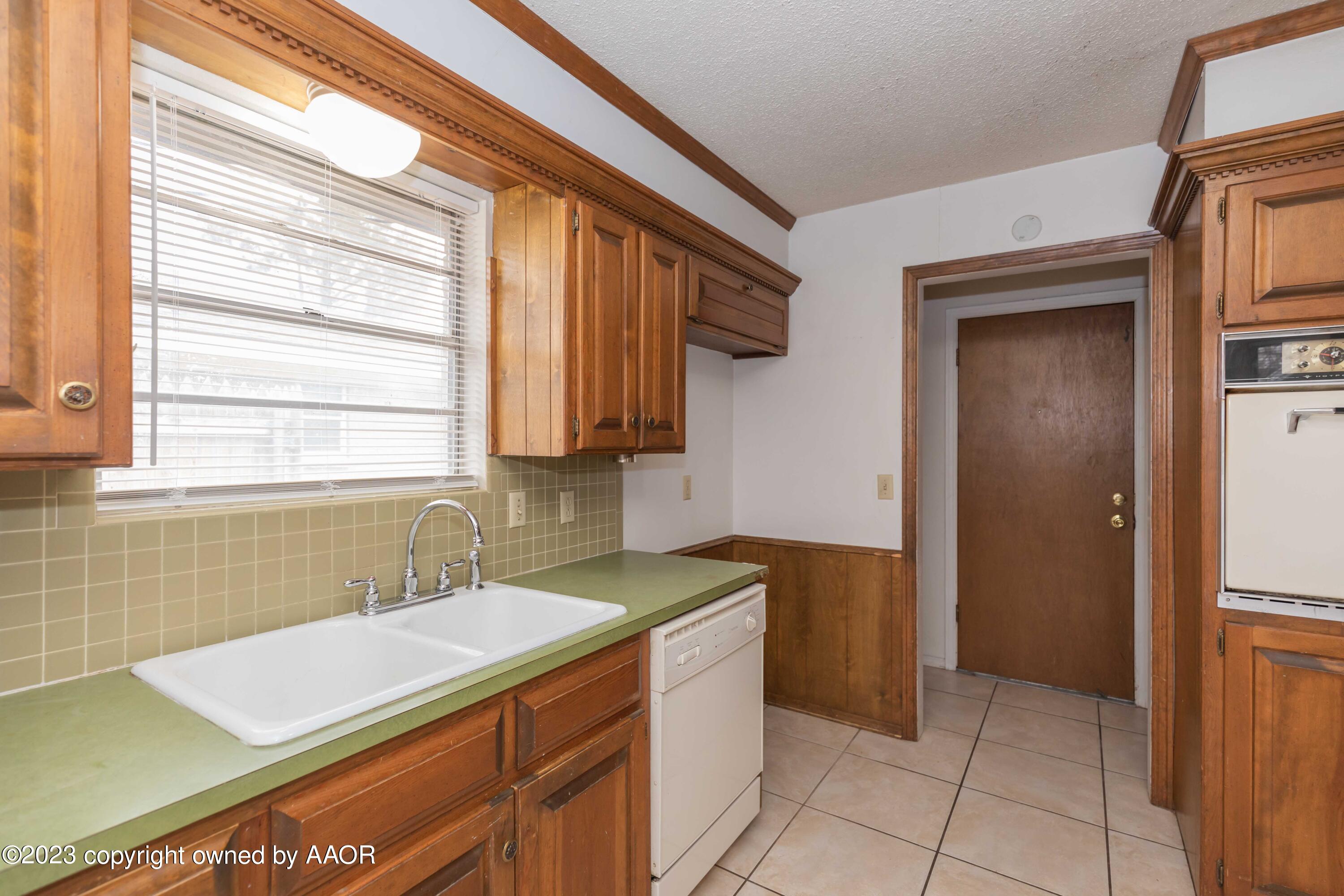 3410 Harmony Street Amarillo, TX 79109 - Photo 9 of 41 a kitchen with a sink cabinets and a window