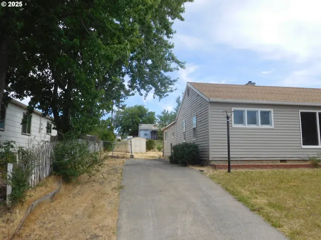 a view of a house with a backyard and trees