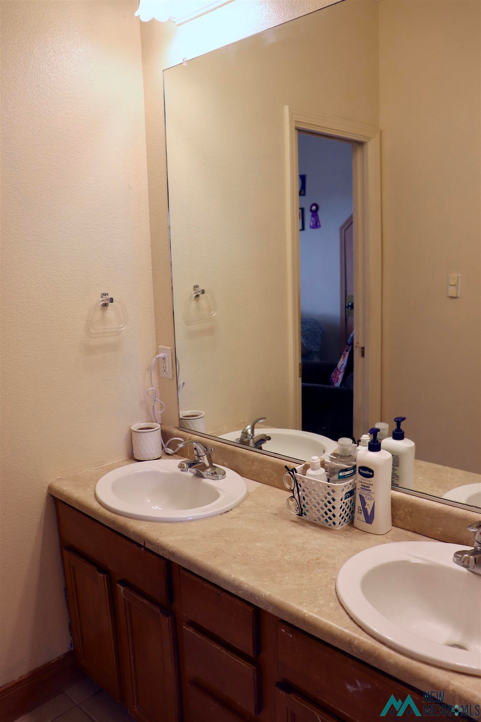 845 South Roosevelt Road South Portales, NM 88130 - Photo 31 of 47 Full bathroom with double vanity, connected bathroom, and tile patterned flooring