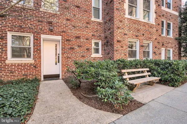 front view of a brick house with a yard