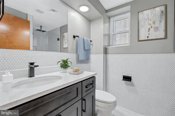 a bathroom with a sink a toilet a mirror and shower