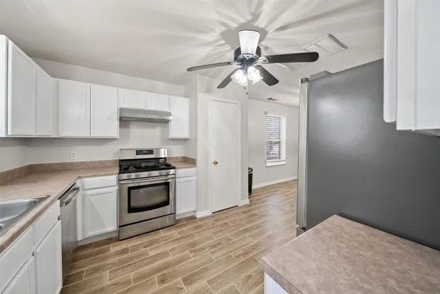 a kitchen with stainless steel appliances a stove a refrigerator and cabinets