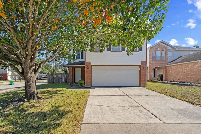 a front view of a house with a yard and trees