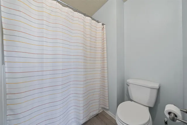 a white toilet sitting next to a white wall