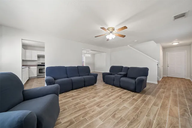 a living room with furniture a ceiling fan and a rug