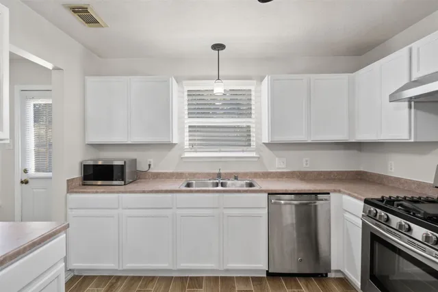 a kitchen with stainless steel appliances granite countertop a stove a sink and a microwave