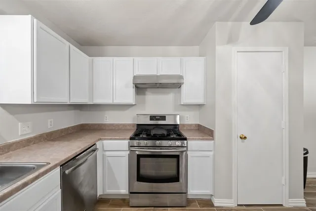 a kitchen with a stove and white cabinets