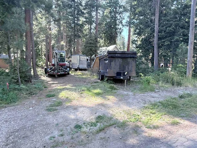 a view of a house with truck parked in a forest