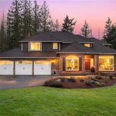 a view of a house with a big yard and large tree