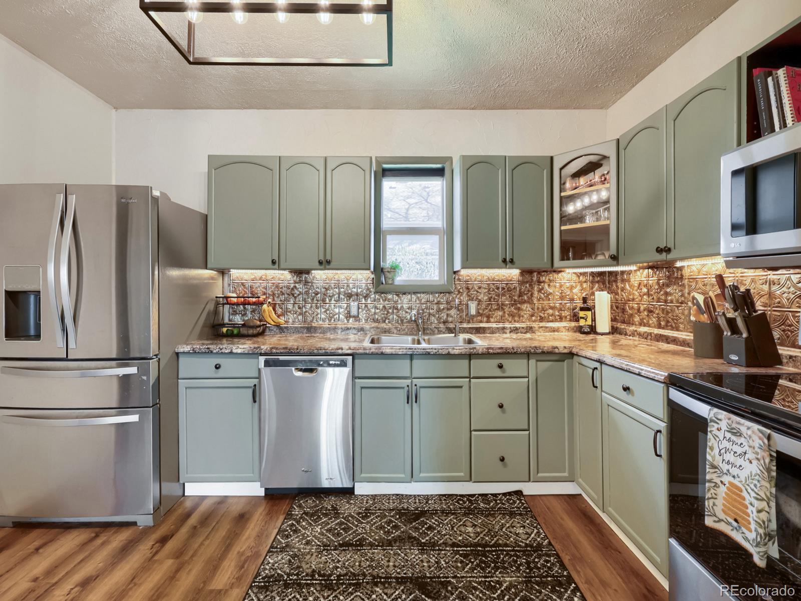 a kitchen with stainless steel appliances granite countertop a refrigerator and a sink