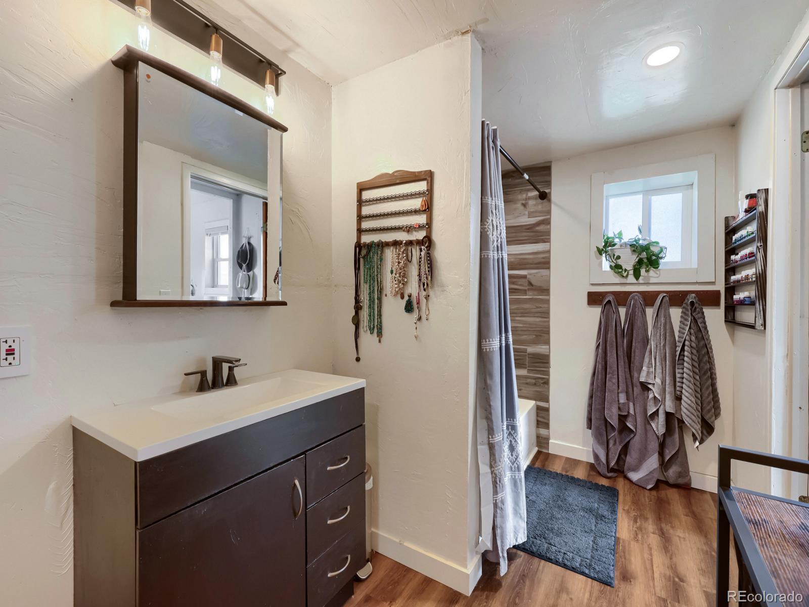 24379 Main Street Elbert, CO 80106 - Photo 13 of 29 a bathroom with a sink a mirror and a shower