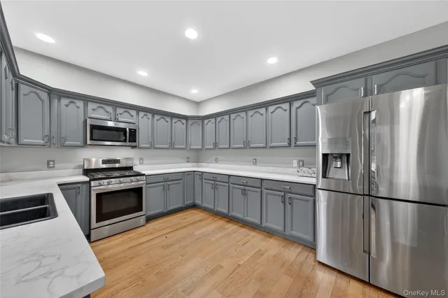 a kitchen with stainless steel appliances granite countertop a refrigerator sink and stove