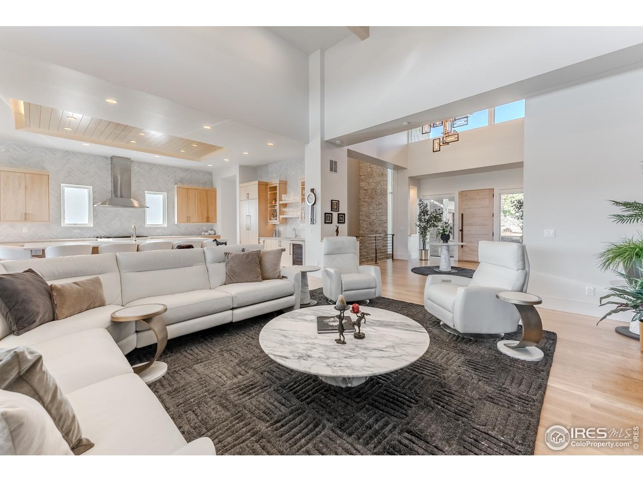 7572 Raphael Lane Littleton, CO 80125 - Photo 15 of 50 The living, kitchen, and dining areas unfold as distinct yet interconnected spaces, each generously scaled and seamlessly linked, creating a sense of openness that feels both expansive and effortlessly unified.