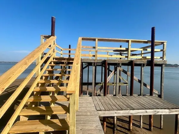 a view of a balcony with chairs and wooden floor