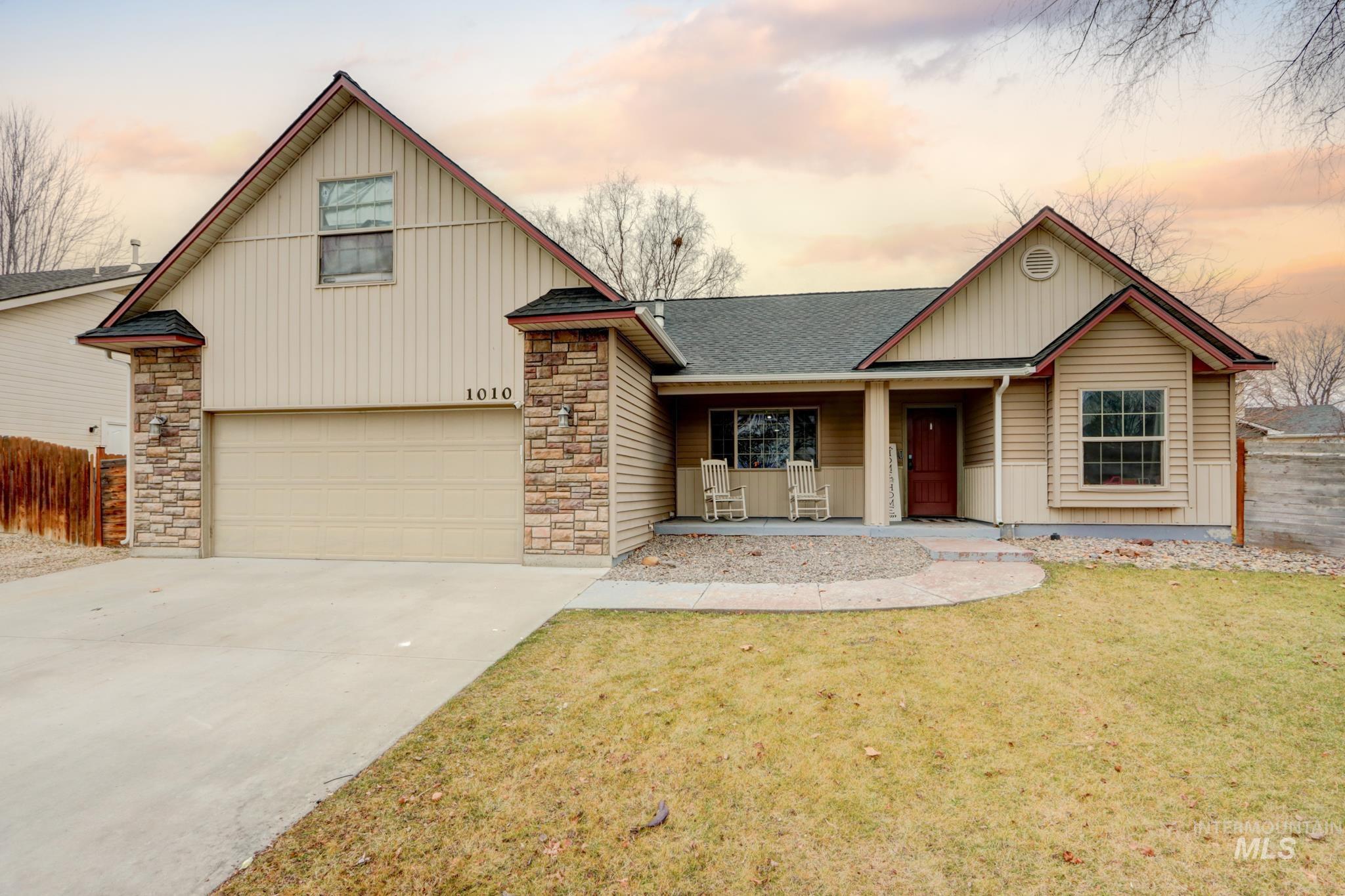 View of front of property with a porch, a shingled roof, concrete driveway, stone siding, and a garage