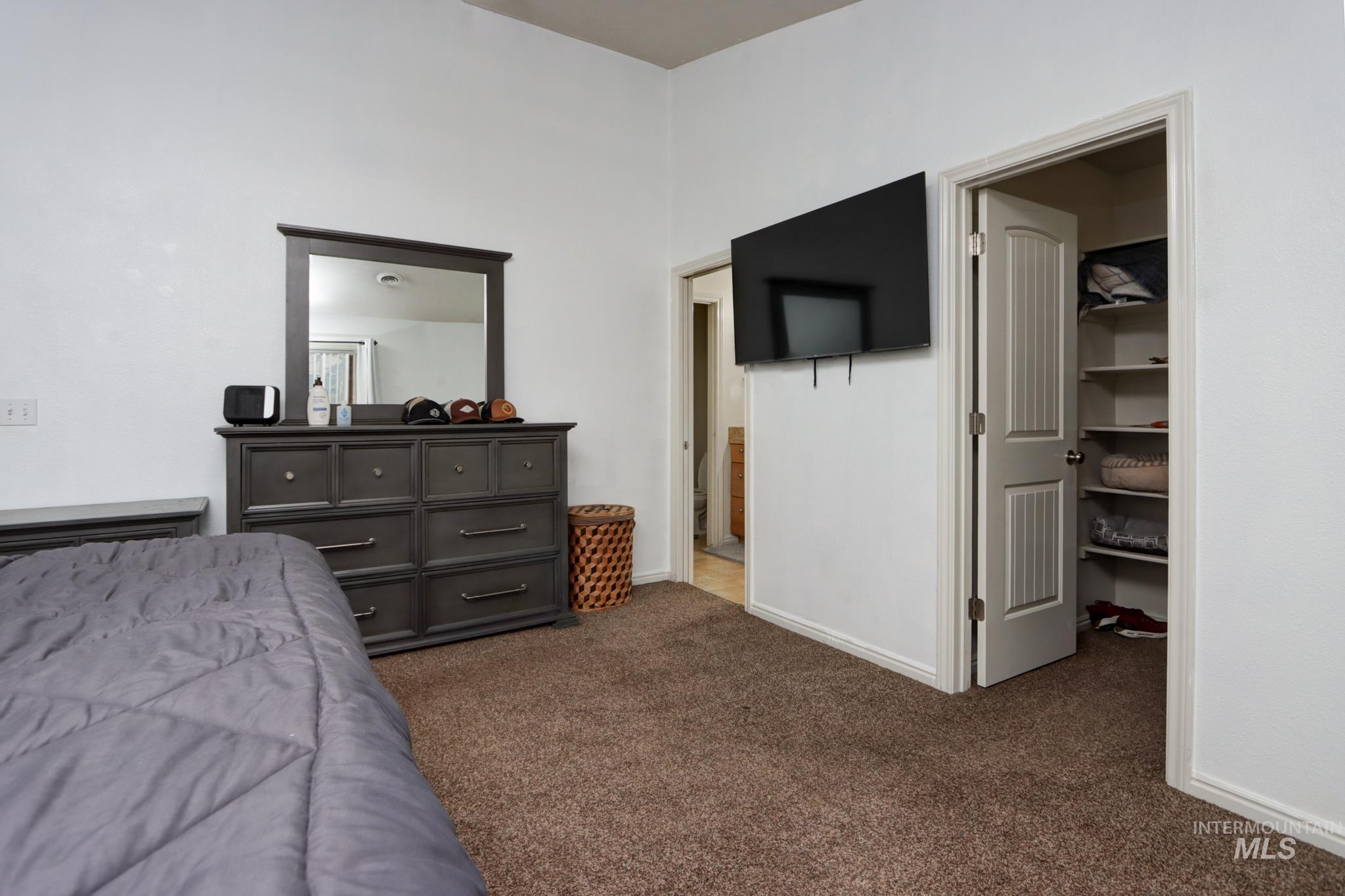 1010 North Rodeo Street Parma, ID 83660 - Photo 10 of 19 Bedroom featuring dark colored carpet and a walk in closet