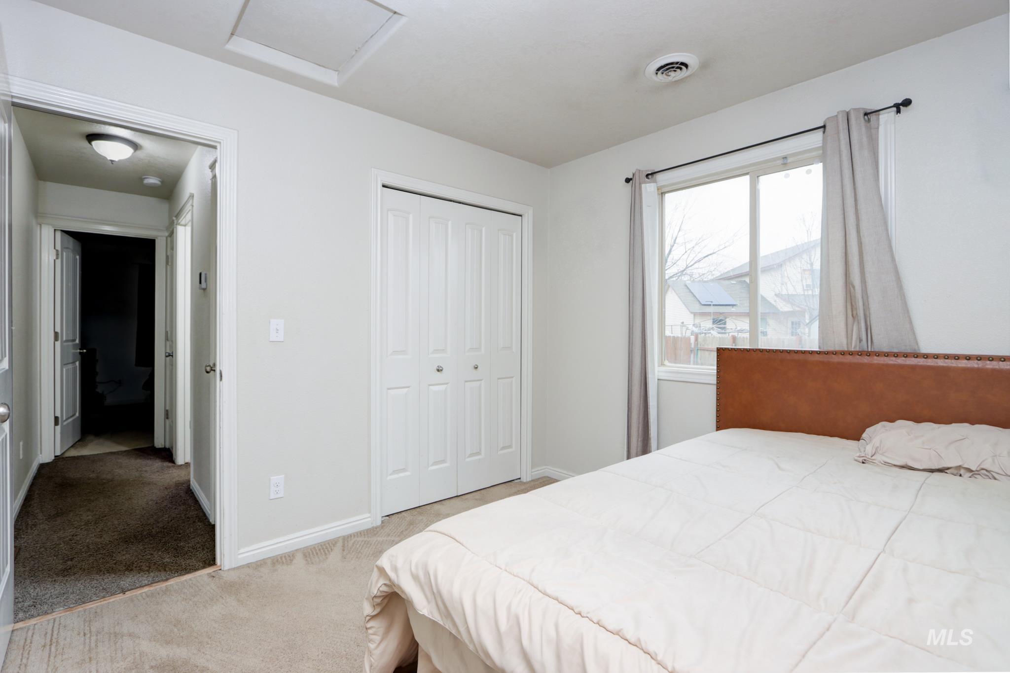 1010 North Rodeo Street Parma, ID 83660 - Photo 13 of 19 Bedroom featuring light carpet, a closet, and attic access