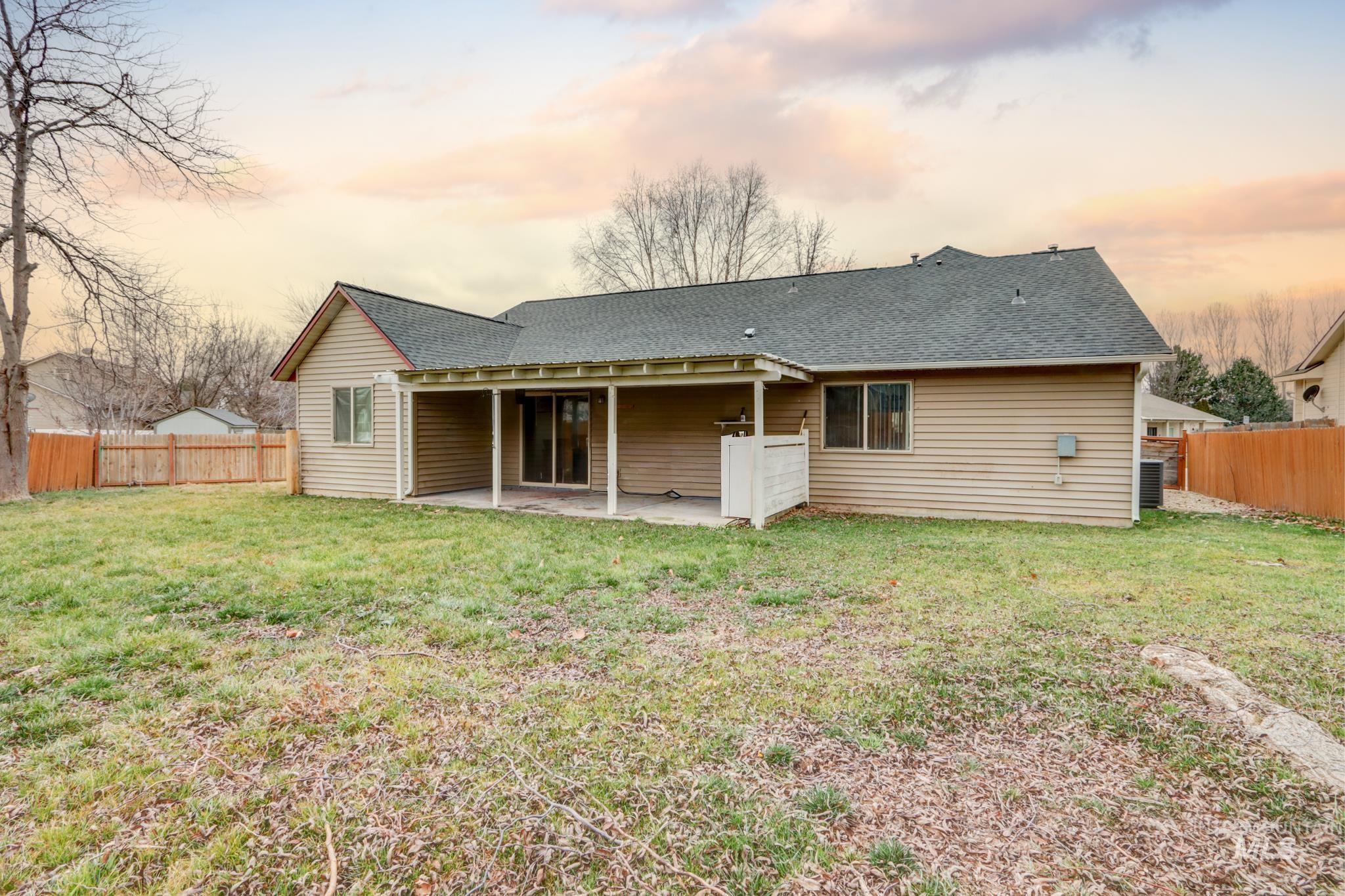 1010 North Rodeo Street Parma, ID 83660 - Photo 17 of 19 Back of property at dusk with a fenced backyard, a patio, and roof with shingles