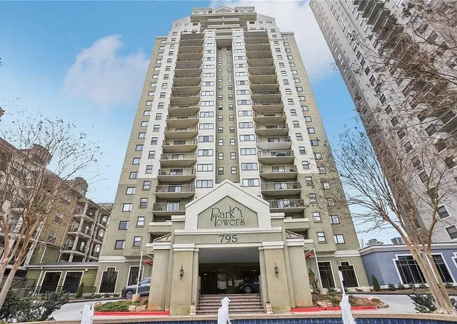 a kitchen with stainless steel appliances kitchen island granite countertop a dining table chairs and a refrigerator