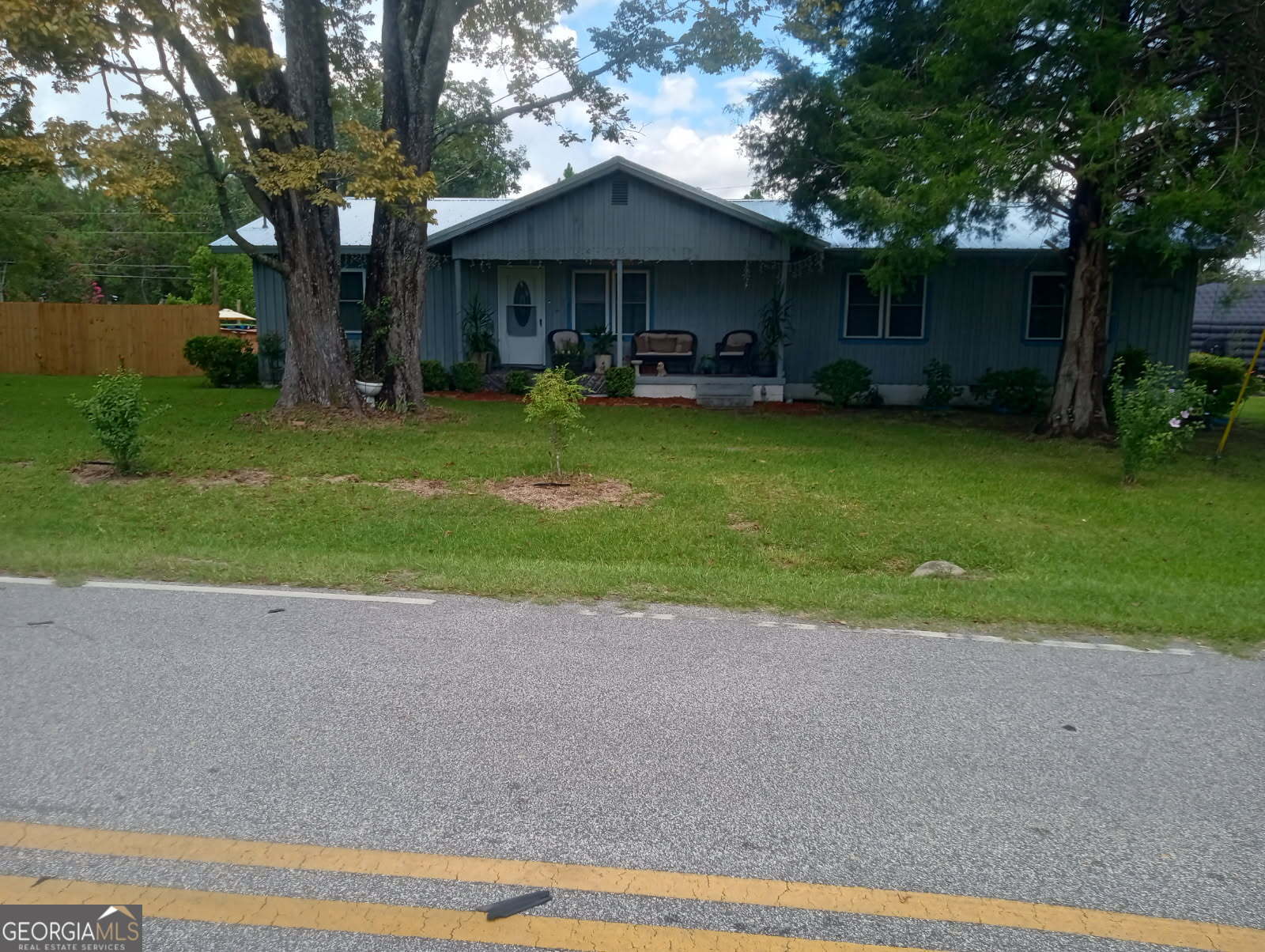 211 Wells Street Swainsboro, GA 30401 - Photo 1 of 19 a front view of a house with a garden and trees