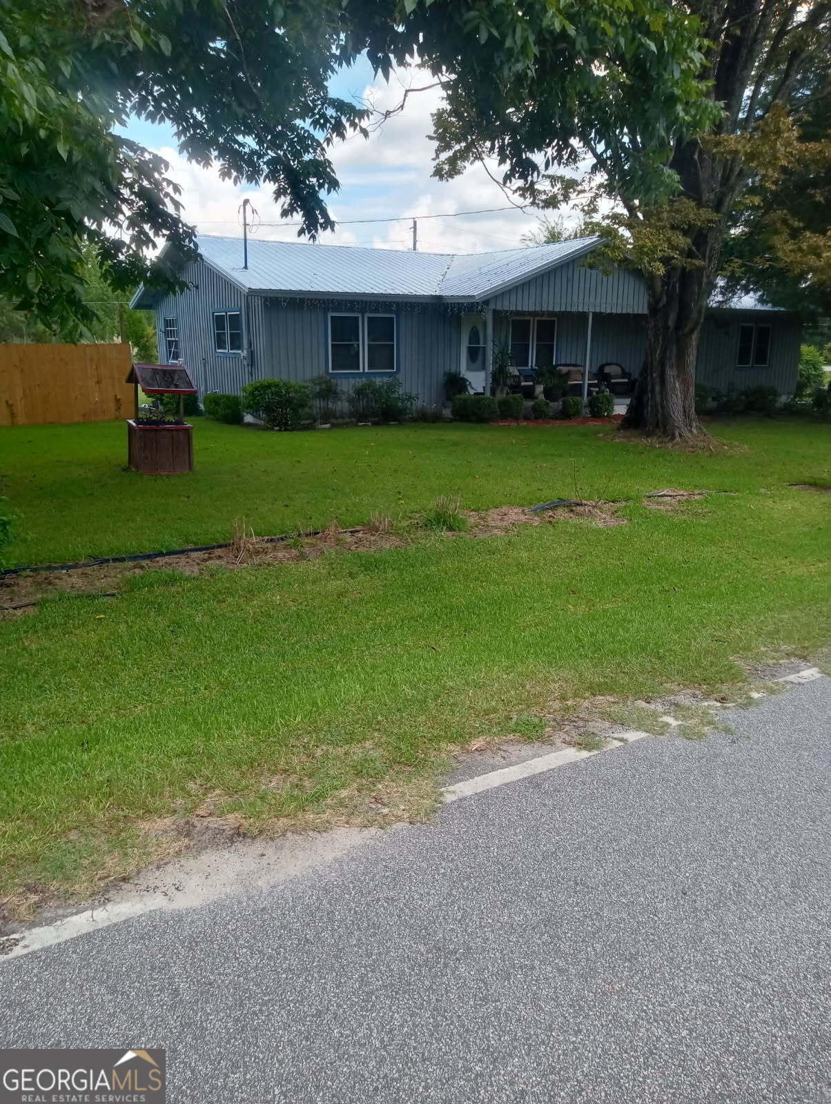 211 Wells Street Swainsboro, GA 30401 - Photo 2 of 19 front view of a house with a yard and trees