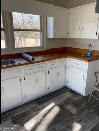 a kitchen with granite countertop white cabinets and window