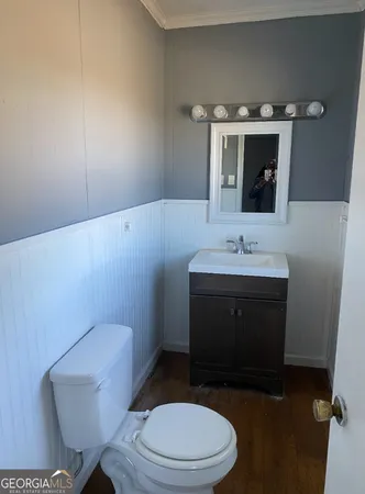 a bathroom with a toilet a sink and mirror