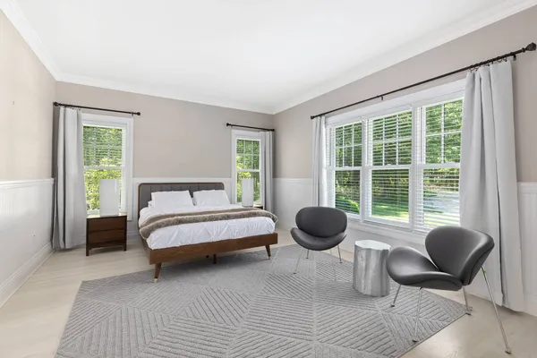 a bedroom with a bed and a large window