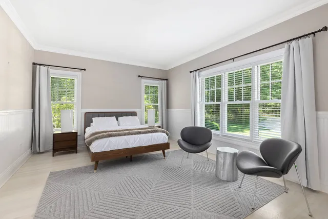 a bedroom with a bed and a large window